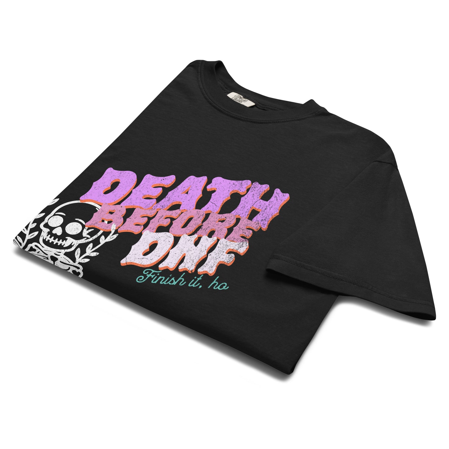Folded black “Death Before DNF” t-shirt flat lay with skeleton illustration and pink lettering, perfect for lovers of dark humor and retro alt fashion.