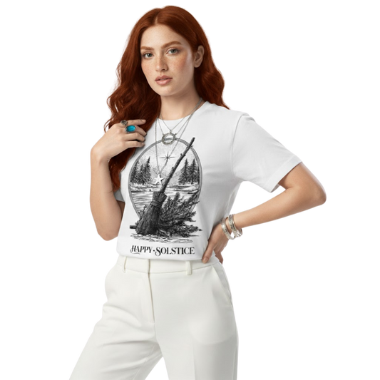 Woman wearing white “Happy Solstice” T-shirt with witchy forest broom design, styled with light jeans and casual pose.