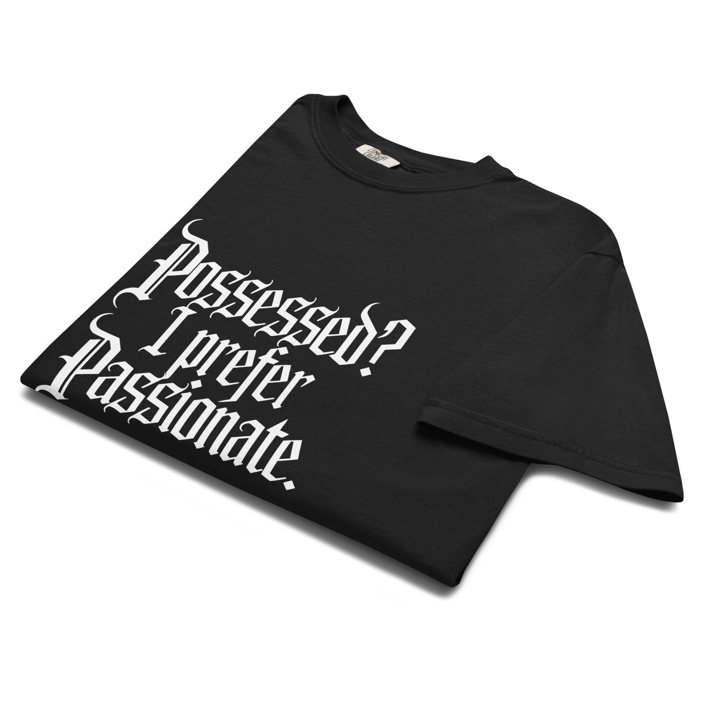 Folded black “Possessed? I Prefer Passionate.” t-shirt flat lay showing white gothic typeface, perfect for witchy romantics and dark academia fashion lovers.