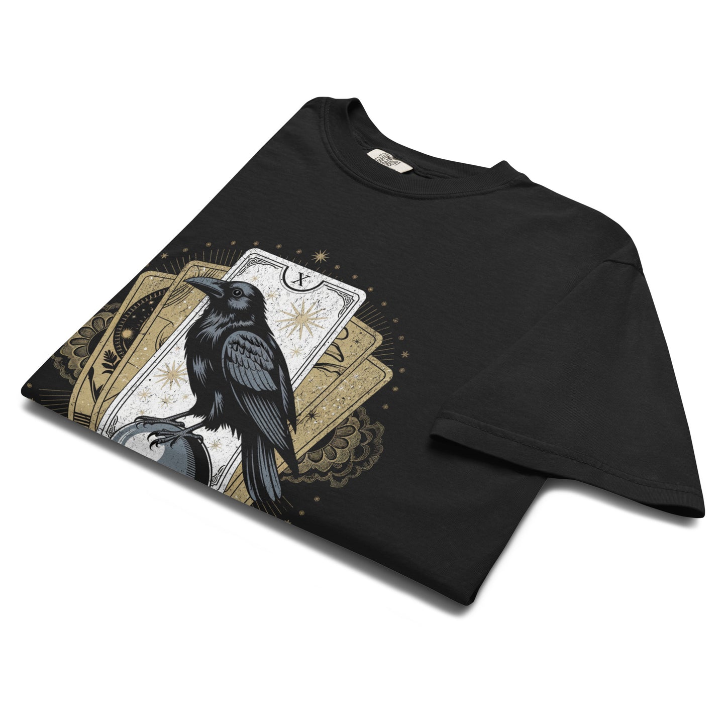 Folded black raven tarot t-shirt flat lay showing detailed mystical artwork with gold accents, perfect for occult fashion and spiritual lovers.