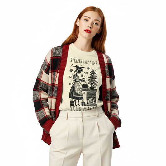 Model wearing cream “Stirring Up Some Yule Magic” t-shirt styled with flannel and winter tones, perfect for witchy holiday outfits and festive solstice vibes.