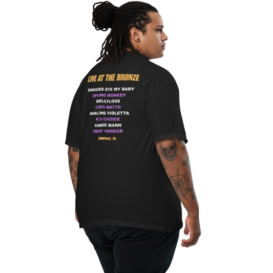Model wearing a black t-shirt with ‘Live at The Bronze’ printed on the back in purple and yellow text; vintage concert-style design.