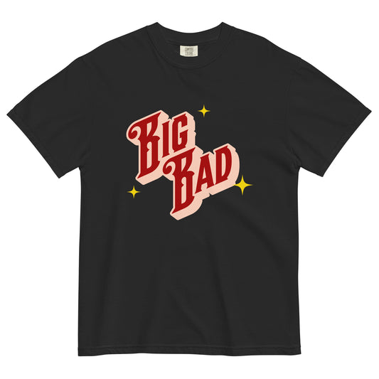 Black t-shirt laid flat with retro red and cream lettering that says ‘Big Bad,’ surrounded by yellow star accents.