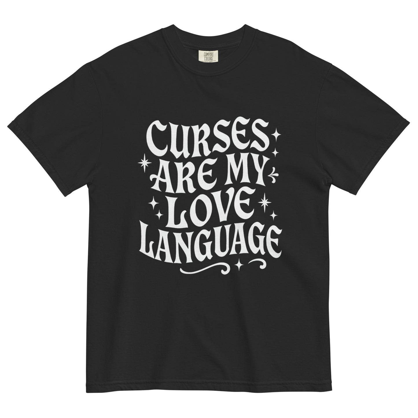 Black t-shirt laid flat with white gothic-style lettering reading ‘Curses Are My Love Language,’ surrounded by small stars.