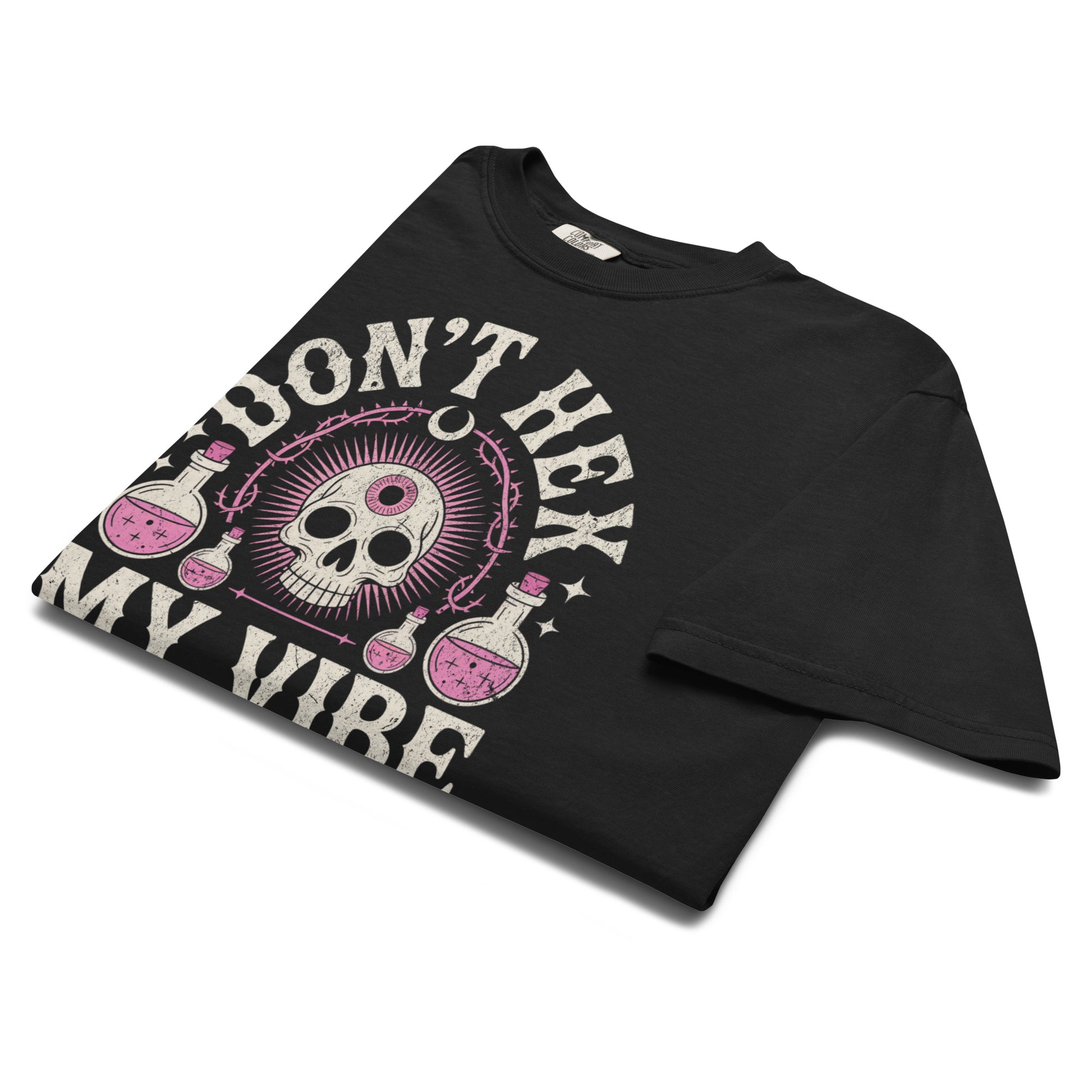Folded Don’t Hex My Vibe T-shirt highlighting vintage pink skull and potion artwork