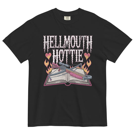 Black t-shirt lay flat featuring pink gothic “Hellmouth Hottie” text above an open spellbook with flames, hearts, and daggers — a darkly flirty witchy graphic tee.