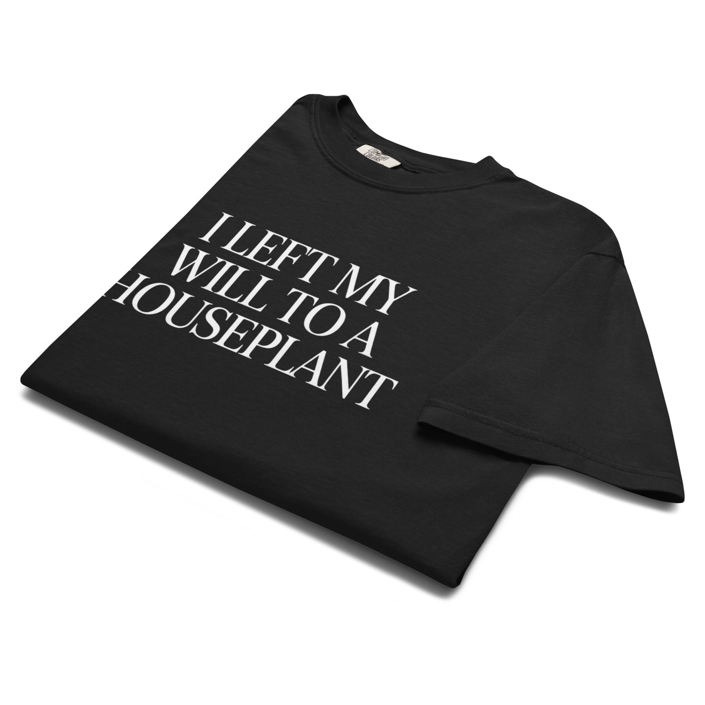 Folded black “I Left My Will to a Houseplant” t-shirt flat lay with minimalist typography, perfect for fans of dark humor and plant parent energy.