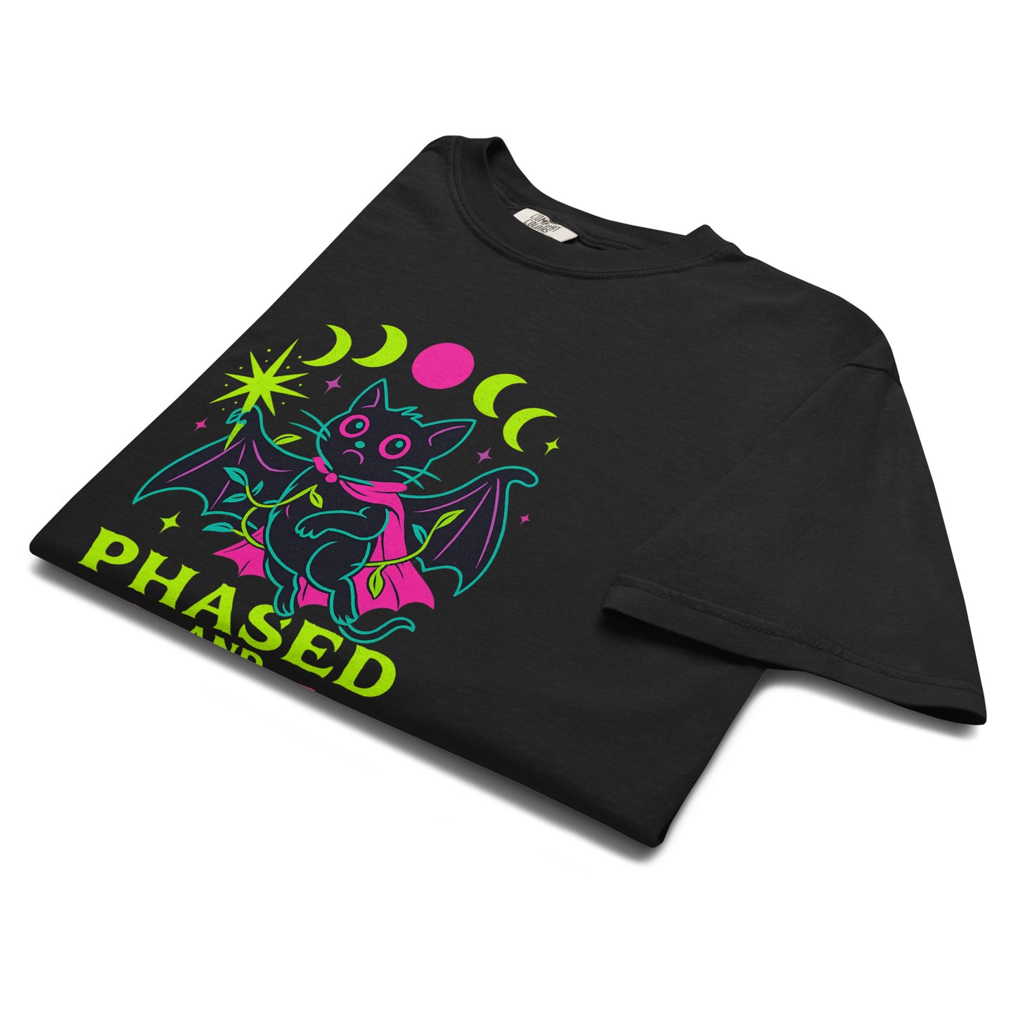 Phased and Confused bat t-shirt folded neatly in a lay flat style, highlighting the vibrant neon colors and celestial moon phase artwork.