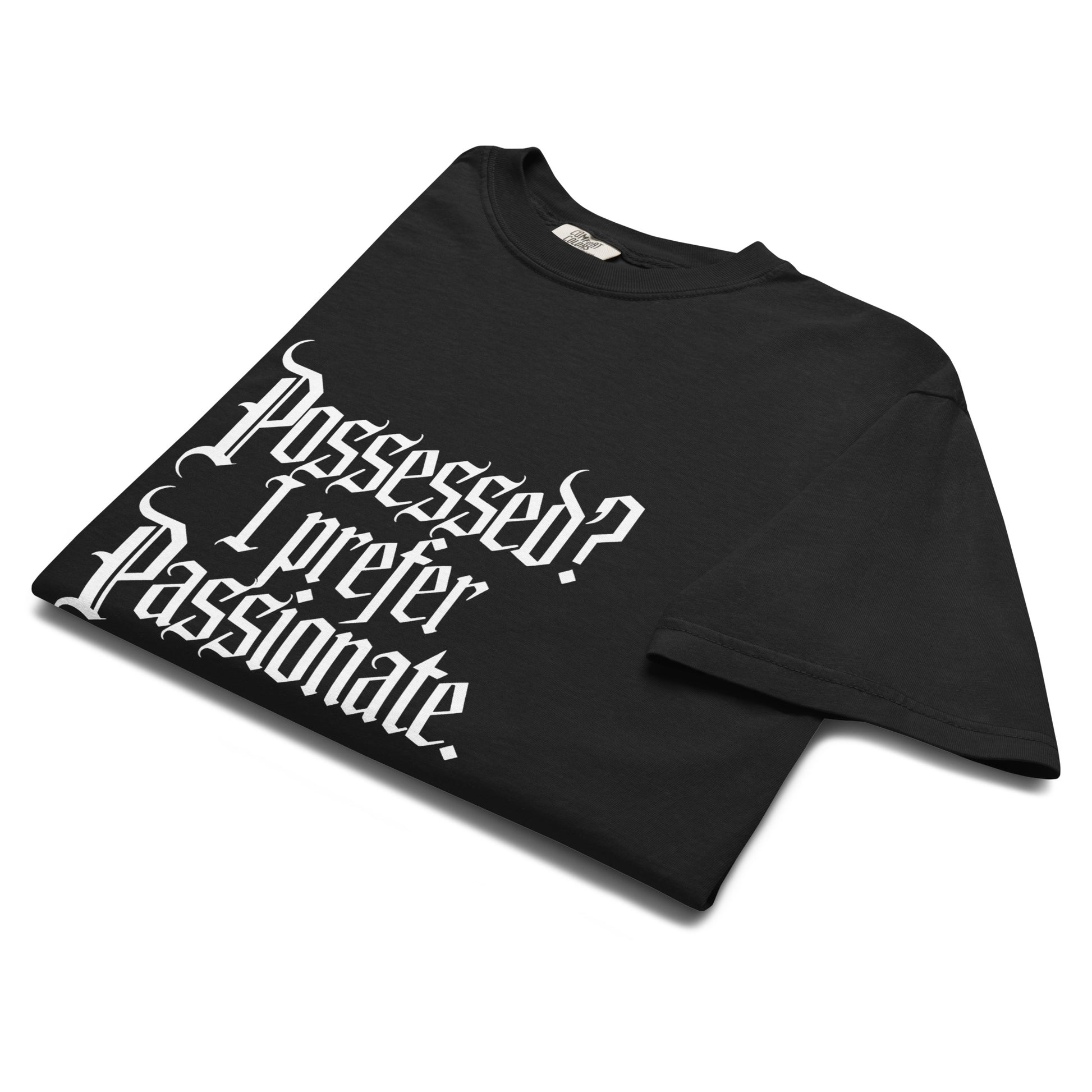 Folded black “Possessed? I Prefer Passionate.” t-shirt flat lay showing white gothic typeface, perfect for witchy romantics and dark academia fashion lovers.