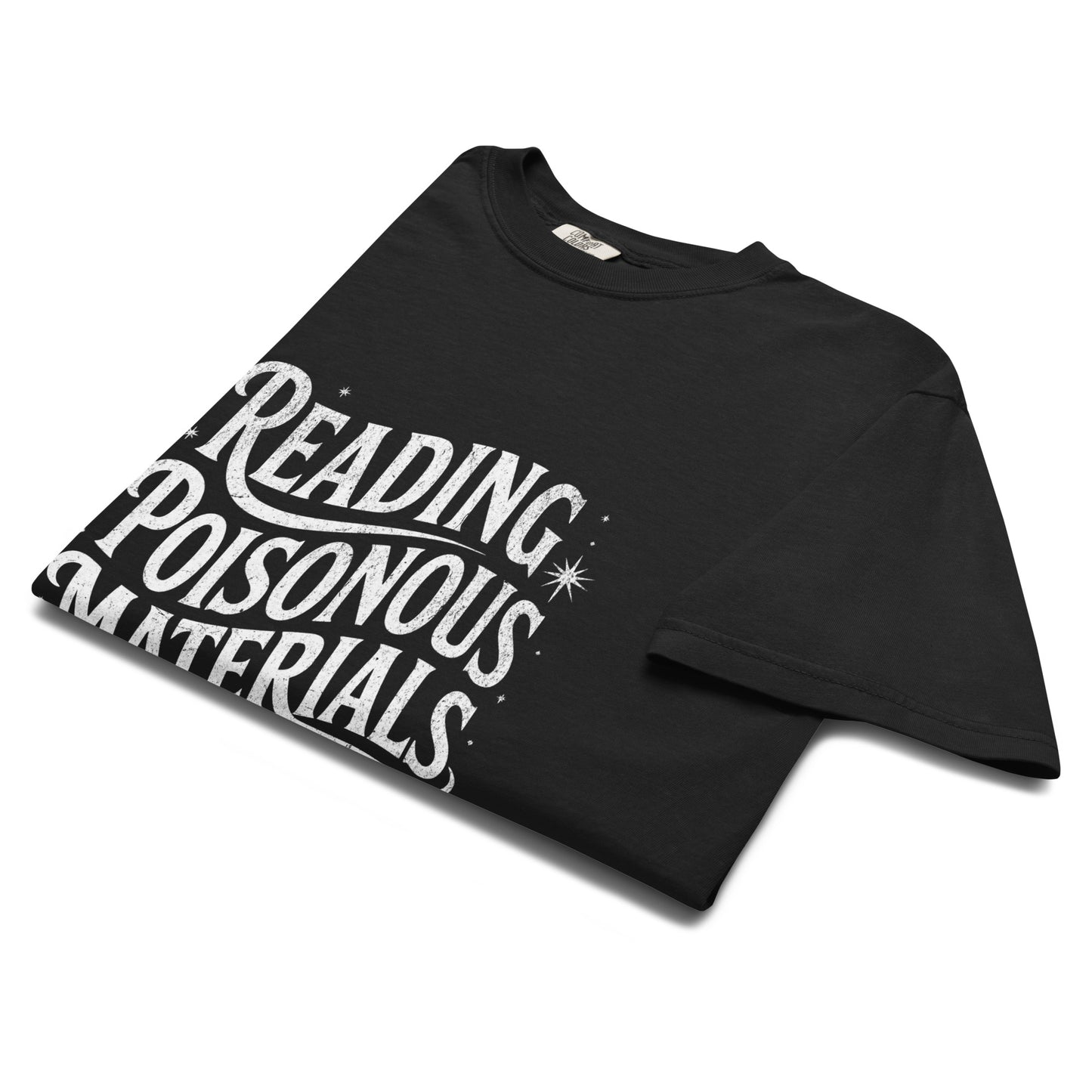 Folded black “Reading Poisonous Materials” t-shirt flat lay showing gothic lettering and star details, perfect for dark academia and literary fashion lovers.