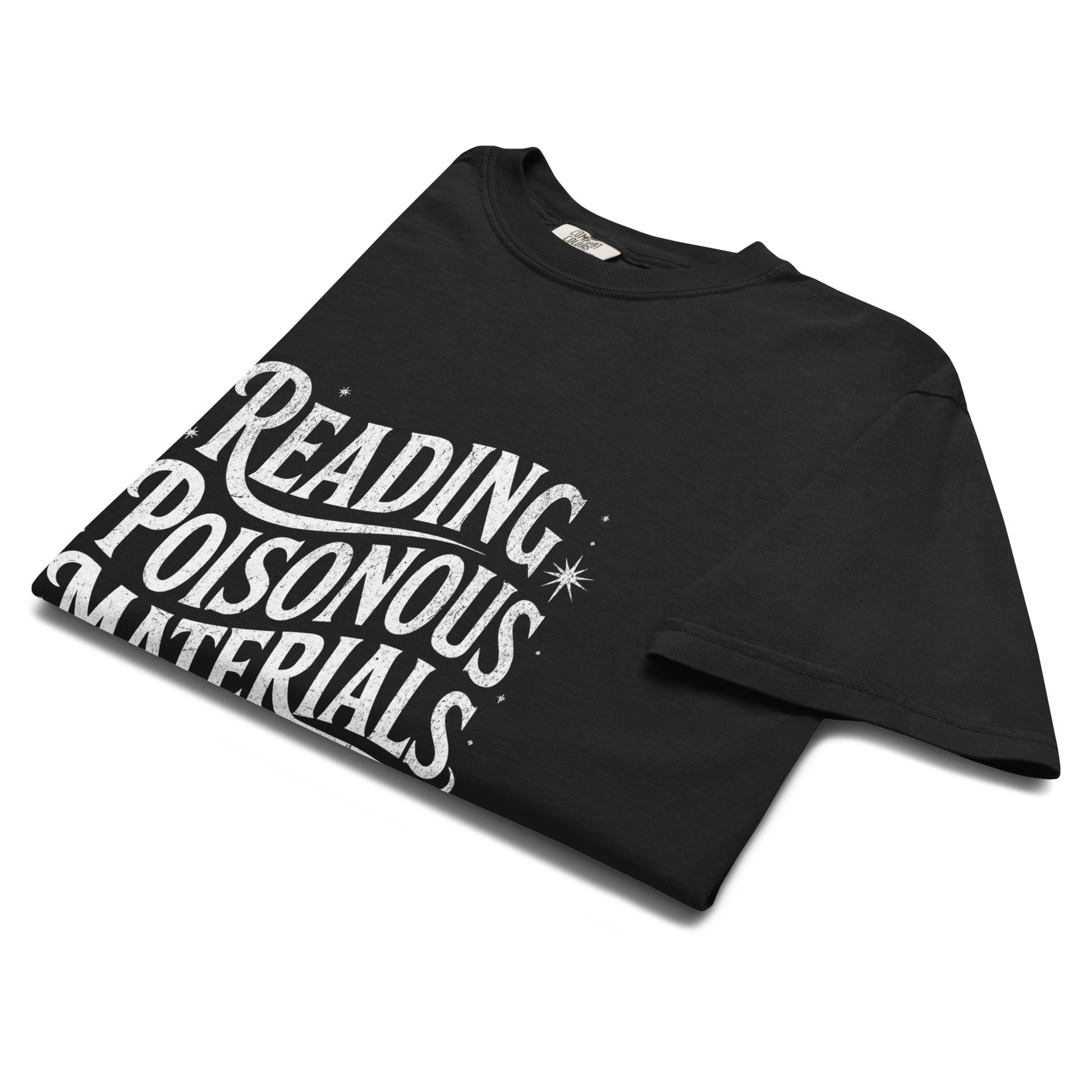 Folded black “Reading Poisonous Materials” t-shirt flat lay showing gothic lettering and star details, perfect for dark academia and literary fashion lovers.