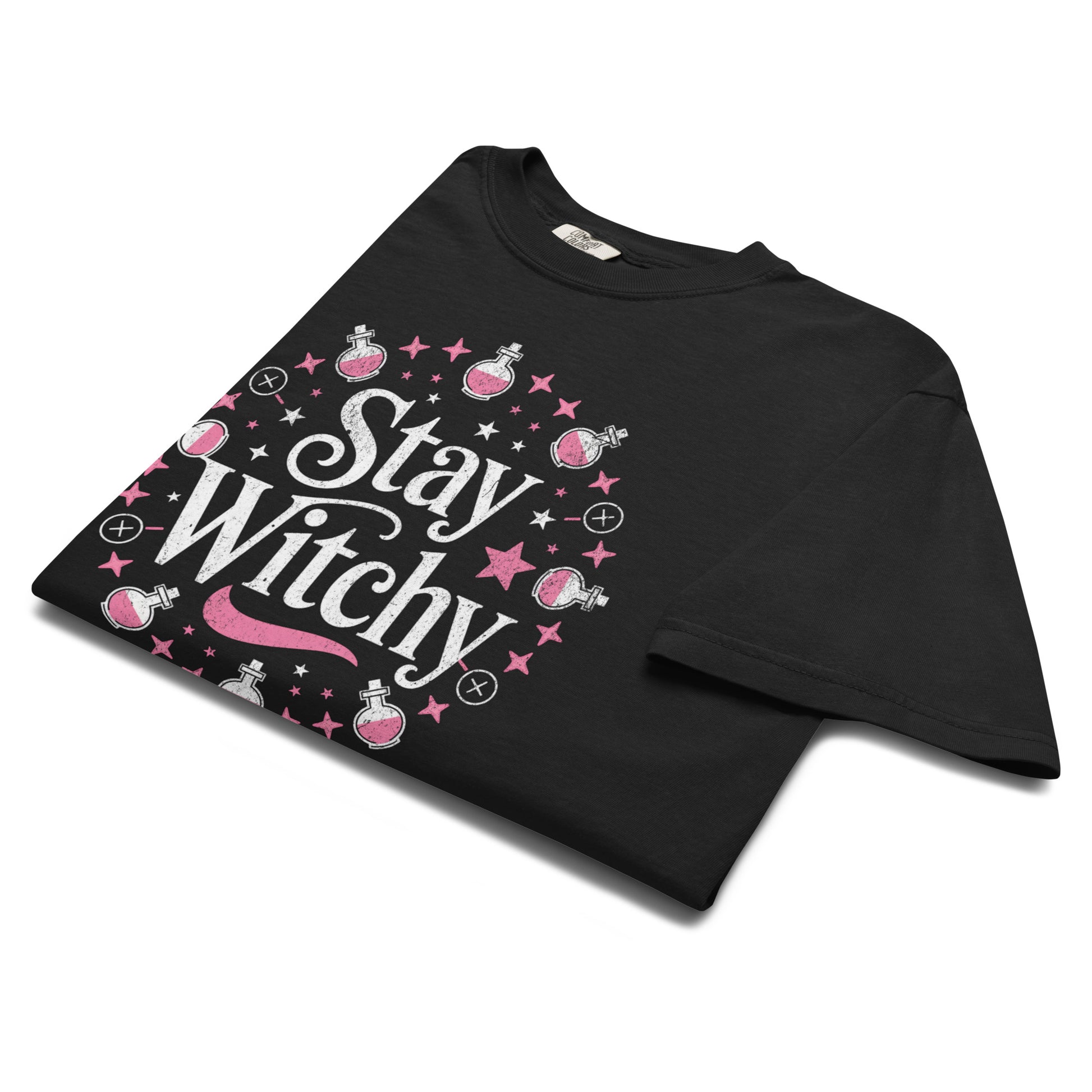 Folded black “Stay Witchy” t-shirt flat lay showing potion bottles, stars, and moons, perfect for witchcore, celestial, and cottage-goth aesthetics.