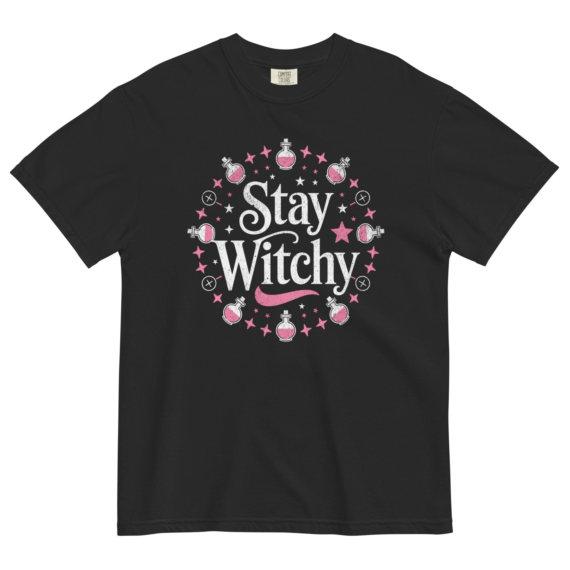 Black t-shirt lay flat featuring whimsical white “Stay Witchy” text surrounded by pink stars, potions, and moons — a playful magical graphic tee for modern witches.