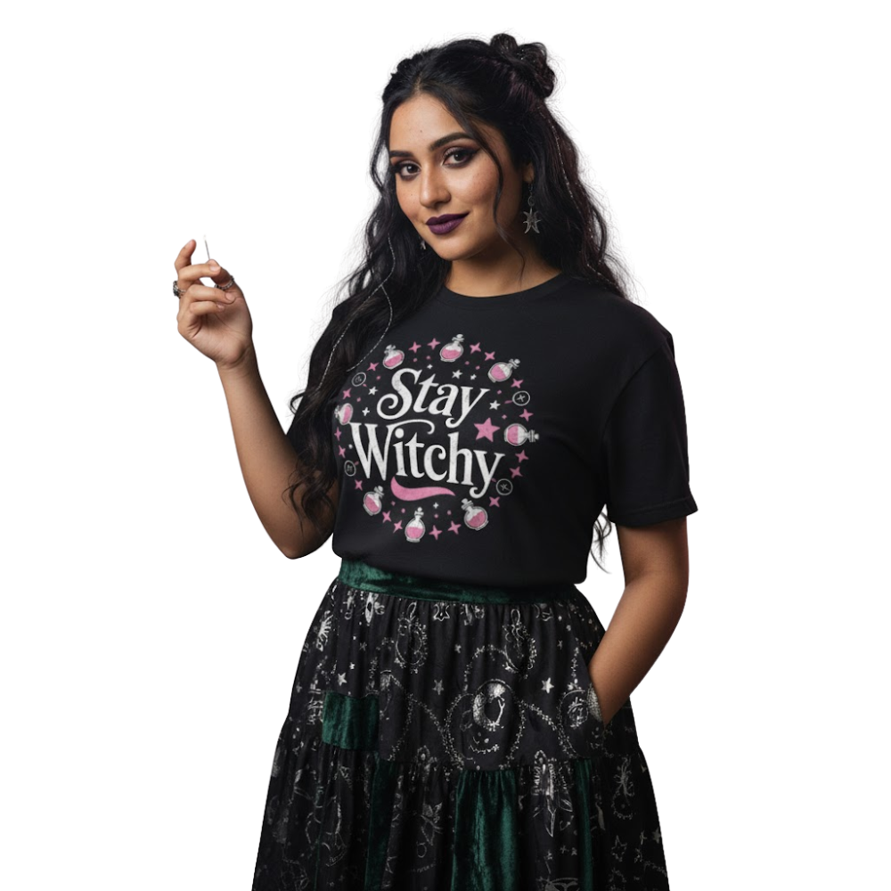 Model wearing black “Stay Witchy” t-shirt with pink and white celestial artwork, styled with a black skirt for a soft gothic or witchy fashion look.