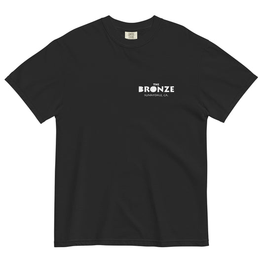 Black t-shirt laid flat with small white text logo reading ‘The Bronze, Sunnydale CA’ on the front left chest.