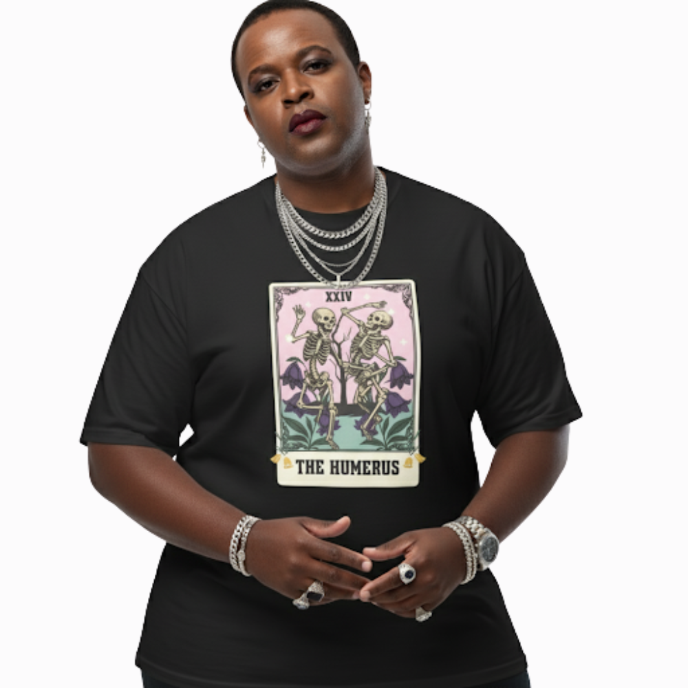 Model wearing black “The Humerus” t-shirt showing tarot card artwork of skeletons among flowers, styled for a mystical yet playful alternative look.