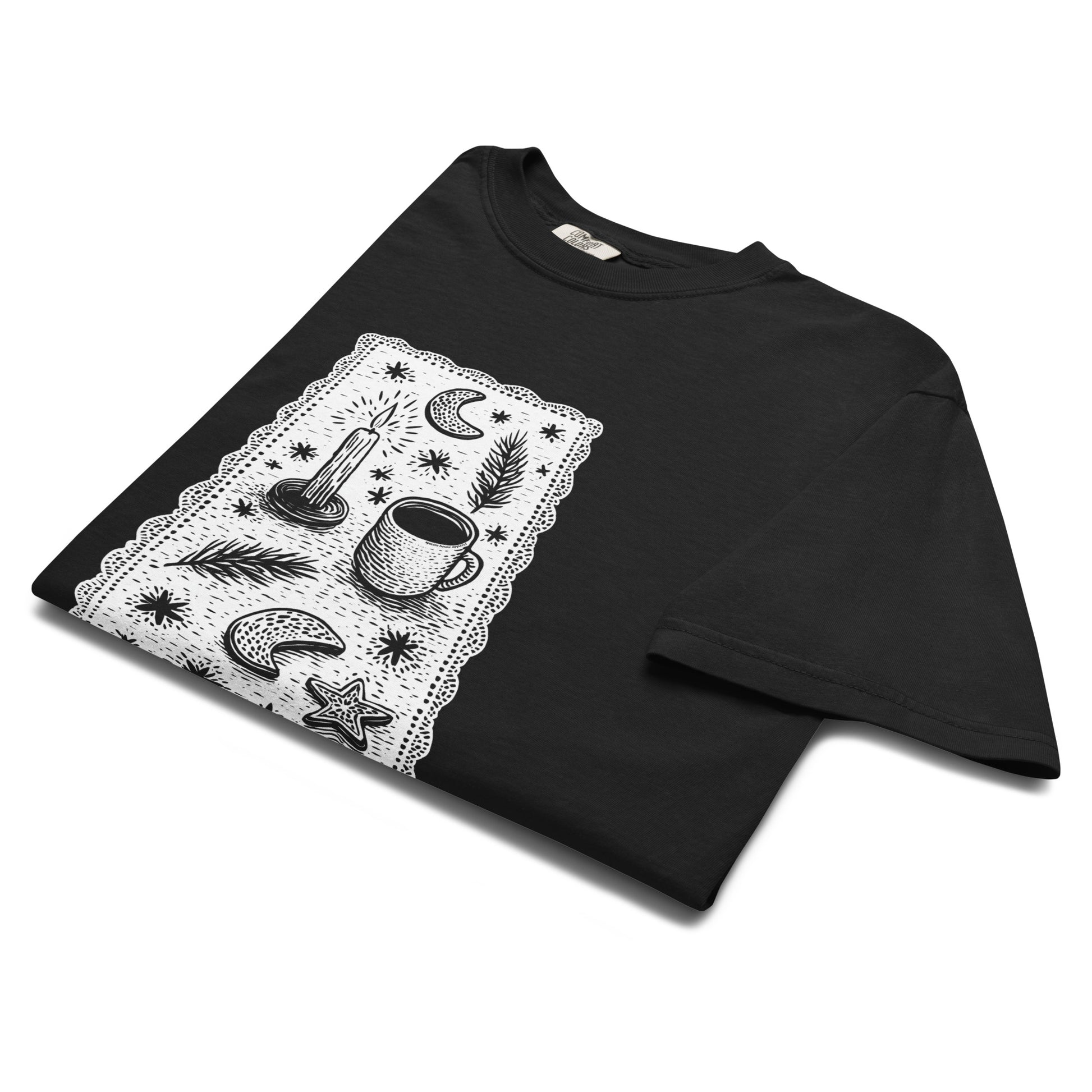 Folded lay-flat view of black witchy coffee and stars T-shirt, showing detailed celestial design print.