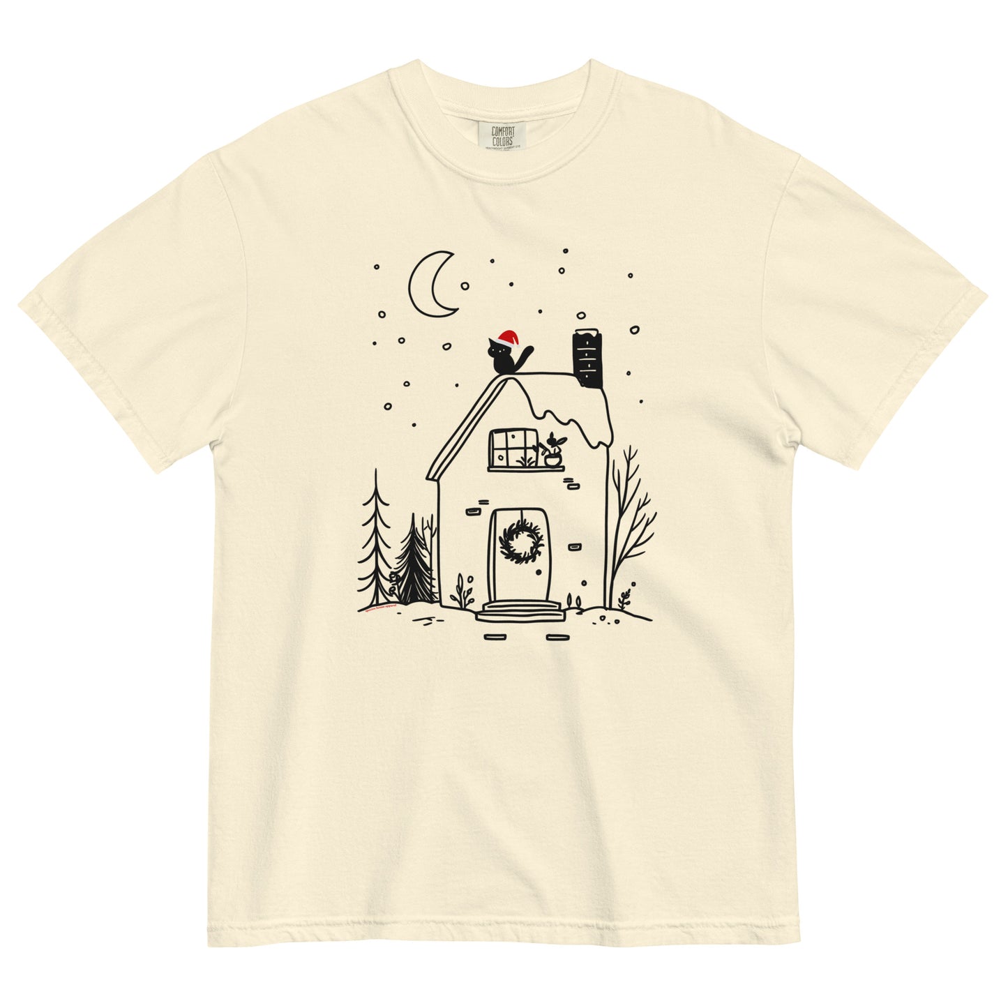 Ivory Comfort Colors T-shirt with cozy witchy cottage design featuring moon, wreath, and snow, shown lay flat on white background.