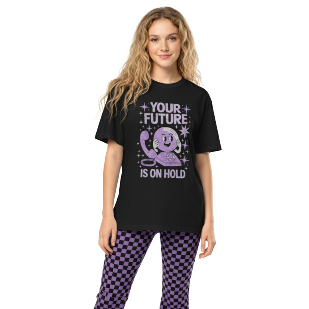 Model wearing black “Your Future Is On Hold” t-shirt featuring a smiling rotary phone graphic and sparkly purple lettering, styled for an alt 2000s-inspired look.